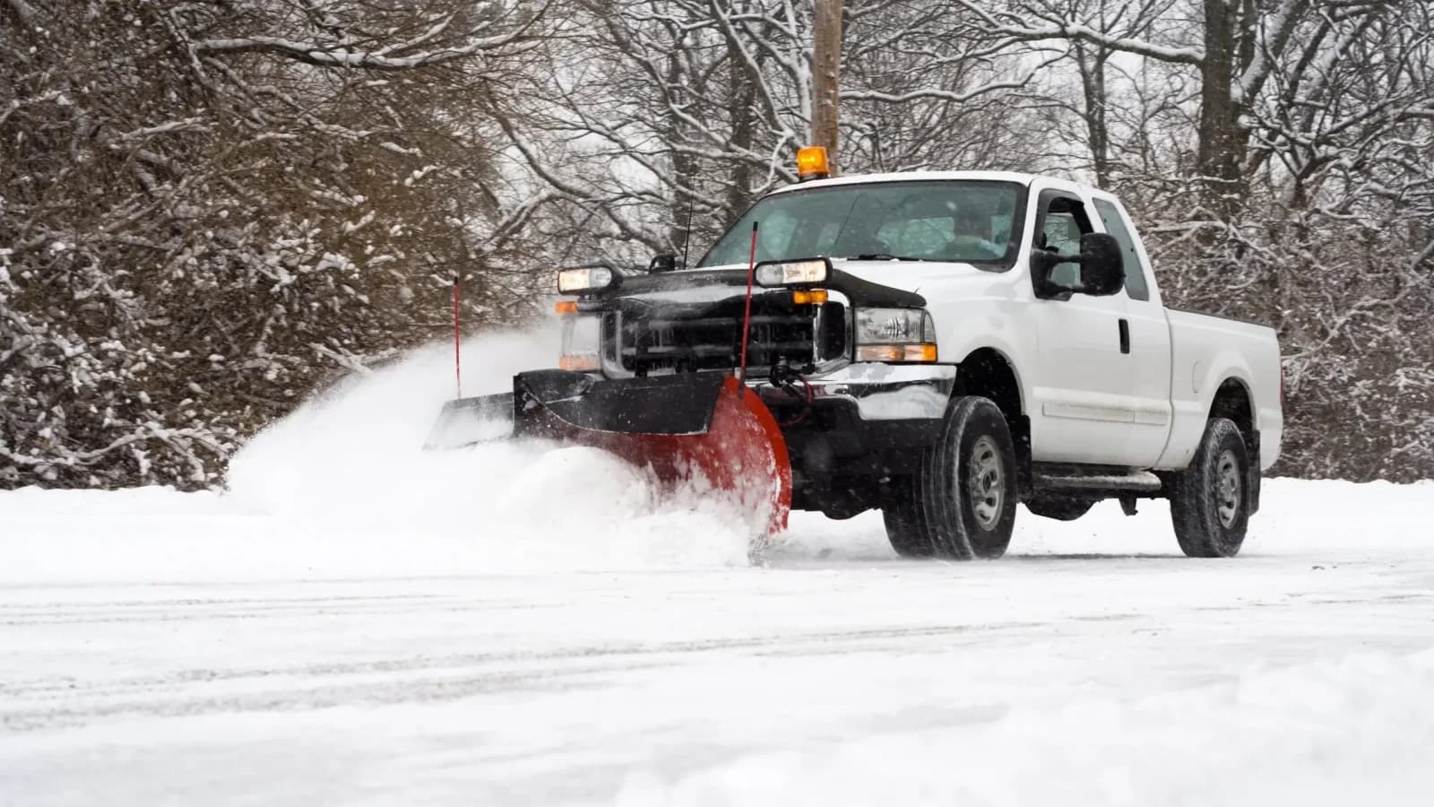 AUI snowplow truck clearing a commercial property