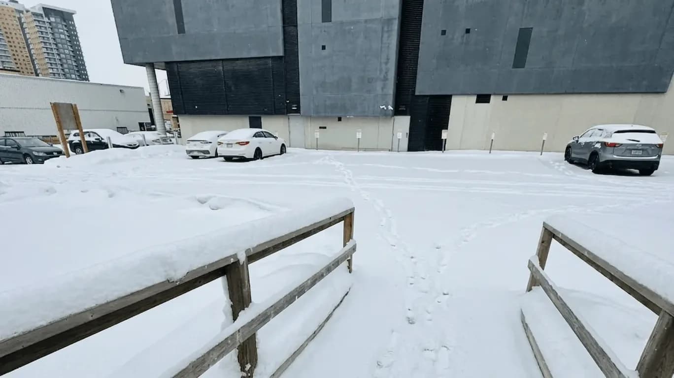 Snow-covered walkway and lot area before service