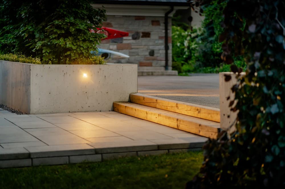 Completed lakeside garden and stone patio with layered planting