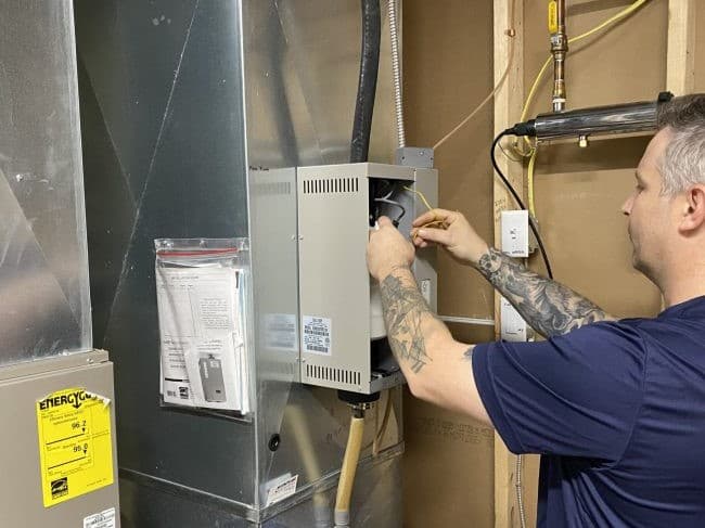 Technician servicing HVAC filter and indoor unit