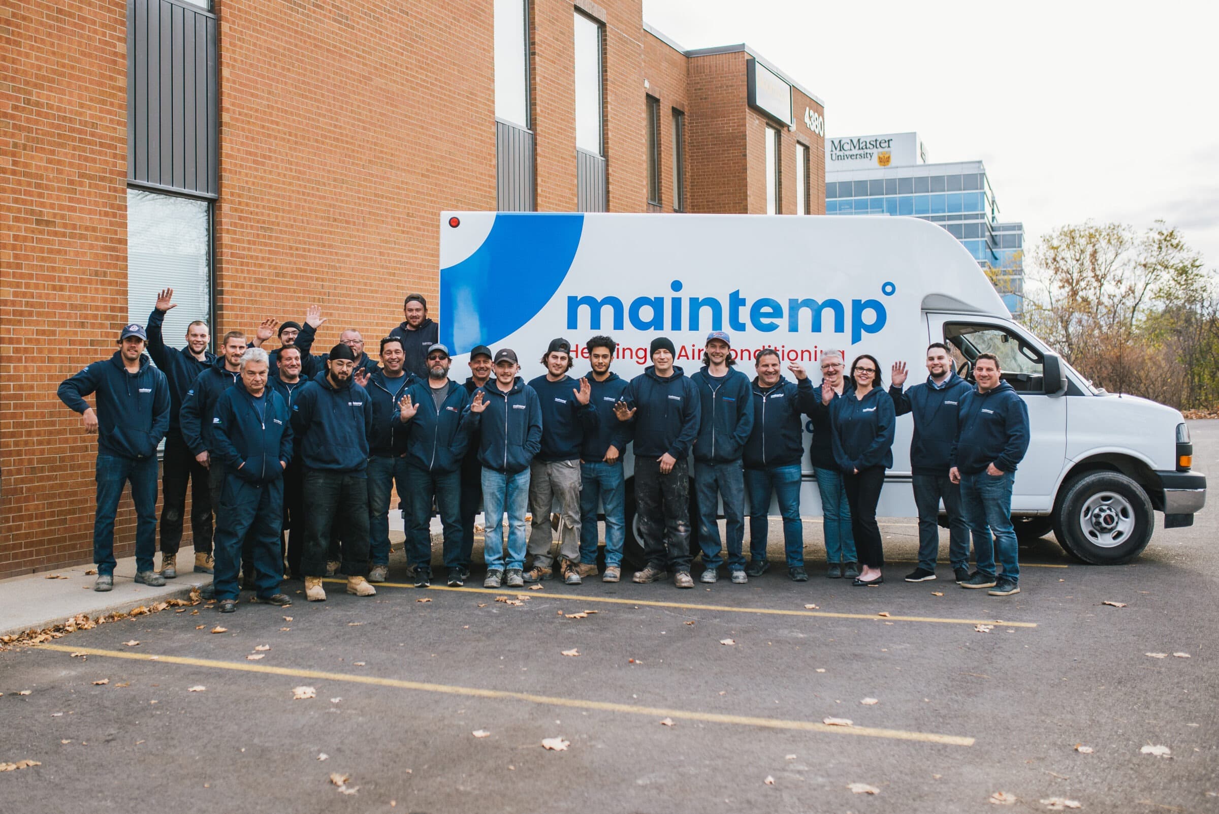 Maintemp team in uniform beside a branded service van